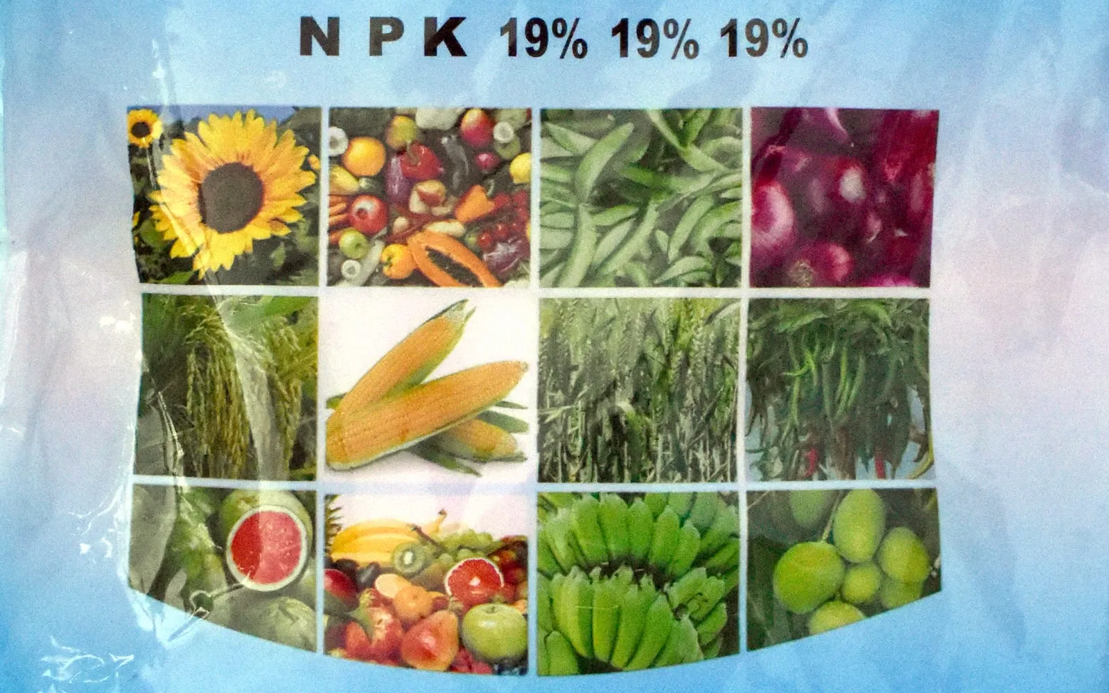 A fertiliser label reading N P K 19 percent 19 percent 19 percent above a grid of photographs of crops, from sunflower and sweetcorn to onions and bananas.
